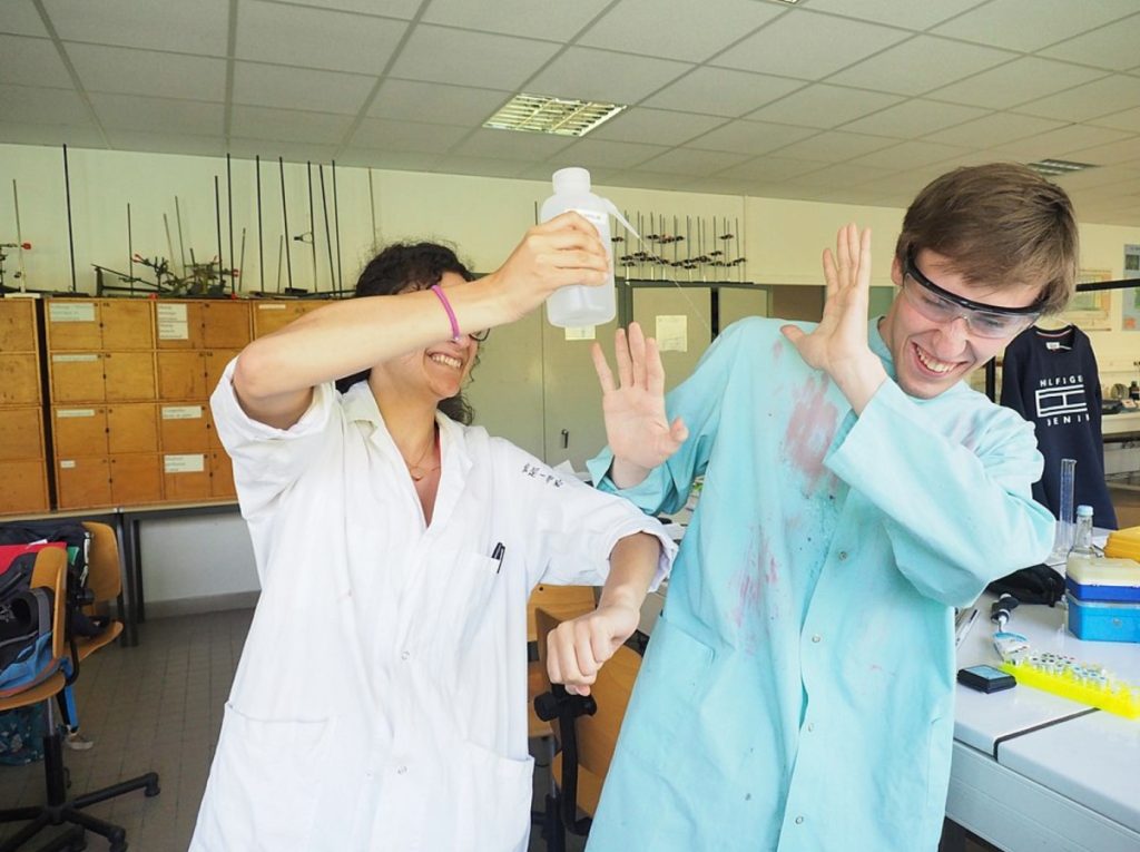 scientist pours a chemical solution on a colleague - conflict resolution