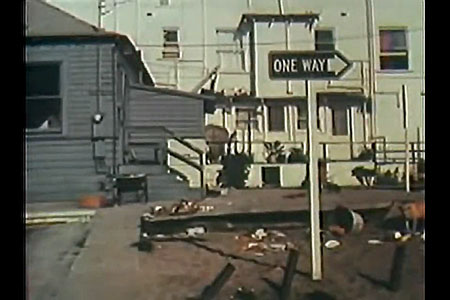 Shot of rundown house with one-way sign in foreground.